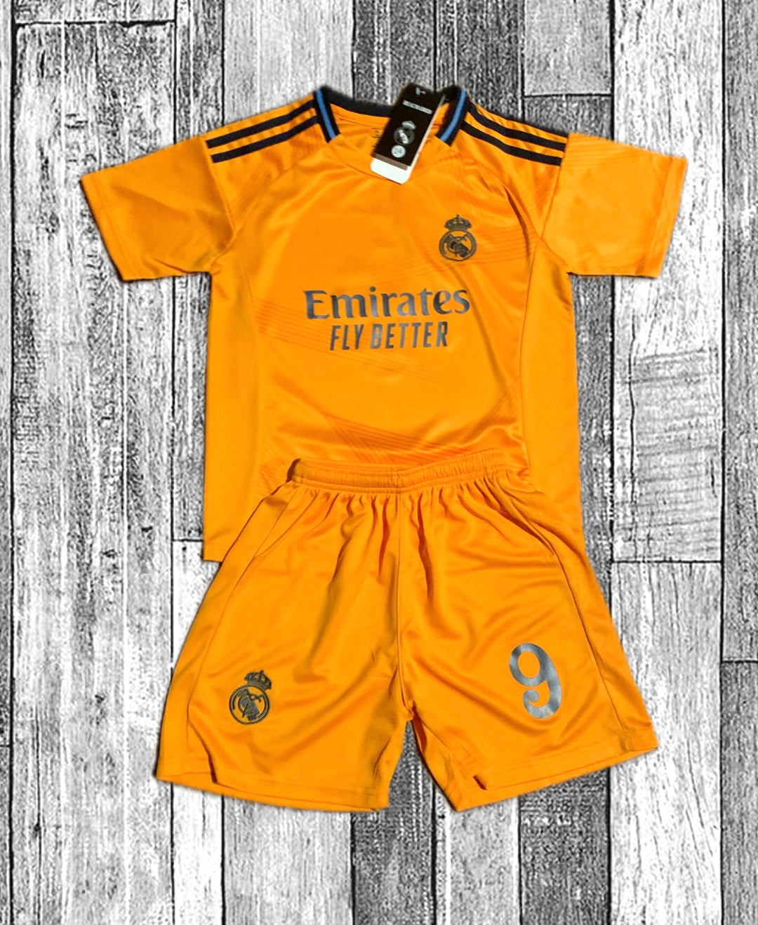 Orange Real Madrid-style kids kit with Emirates Fly Better and shorts number 9