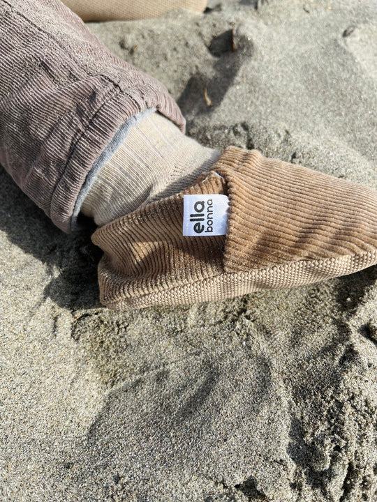 Beige corduroy moccasin shoe with brand patch on ankle