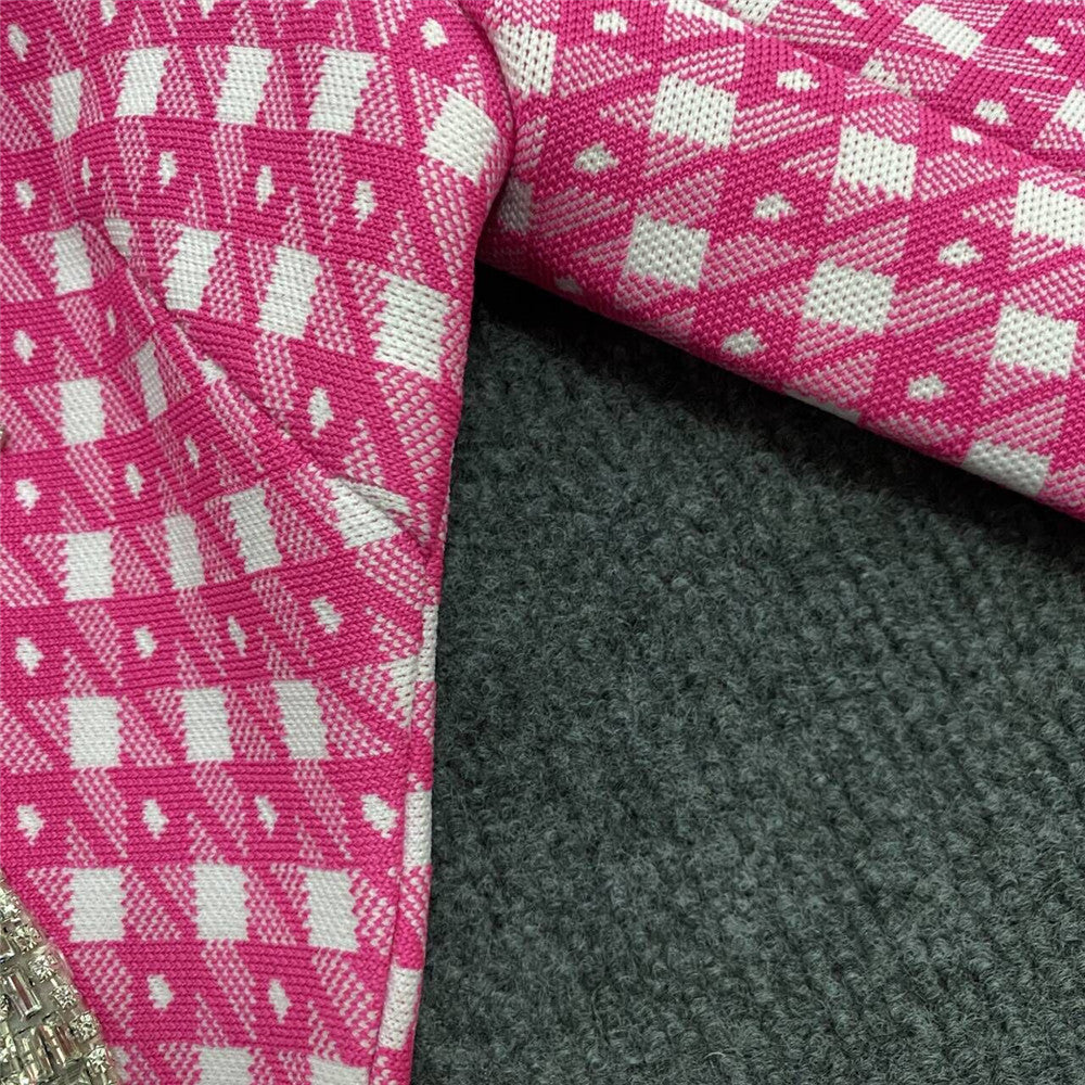 Pink knitted fabric close-up with small check pattern and textured weave