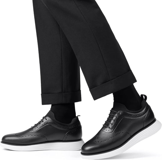Black lace-up wingtip sneakers with perforations and thick white/grey sole