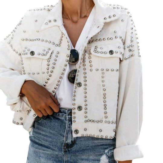 White cropped denim jacket with dense rhinestone trim, button cuffs, and shoulder studs