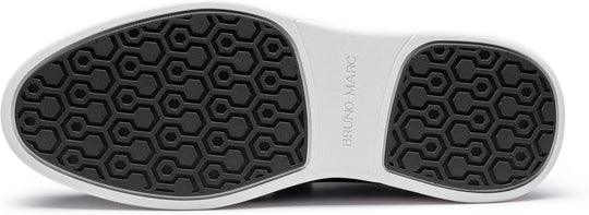 Close-up of black sneaker outsole with hexagonal grip tread and white edge