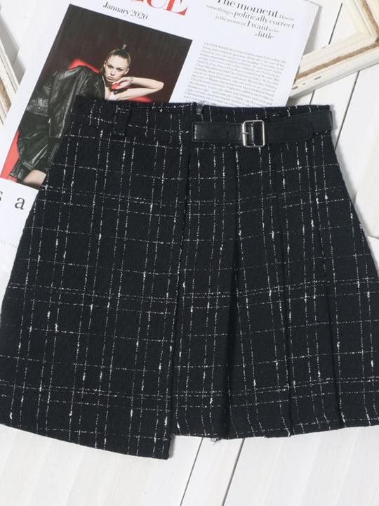 Pleated plaid mini skirt in black with white grid pattern and wide belt