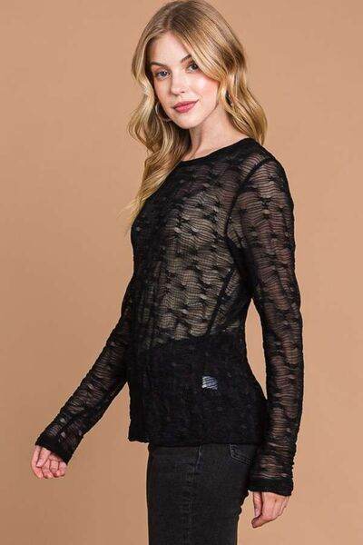 Black mesh women’s top with round neckline and long sleeves, side profile
