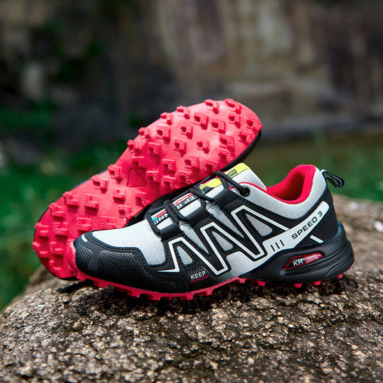Off-road running shoe: light gray/black upper with bright pink outsole, lace-up design.
