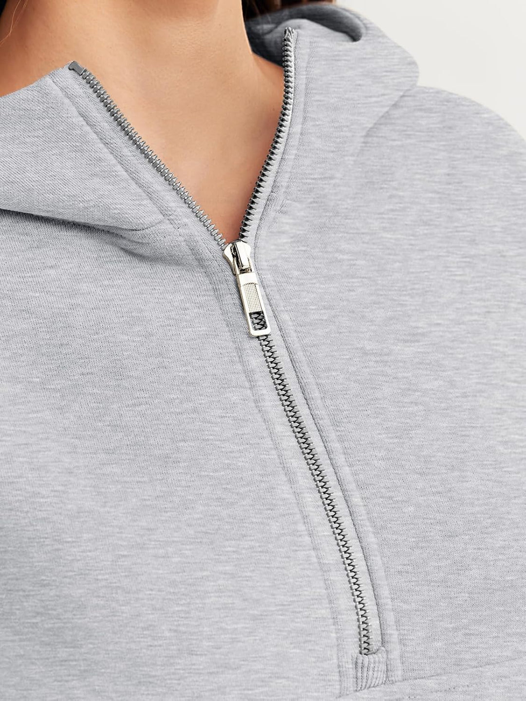 Close-up of quarter-zip on grey hoodie with metal zipper pull