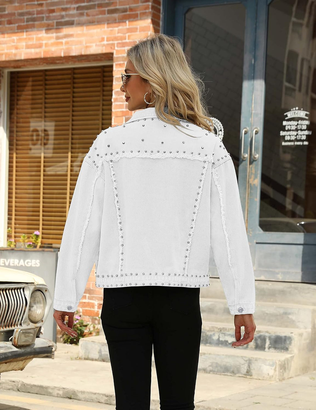 Back view of white cropped denim jacket with silver rivet detailing and button front