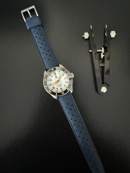 Tropic Bands watch with navy blue perforated strap and silver buckle, detailed black bezel