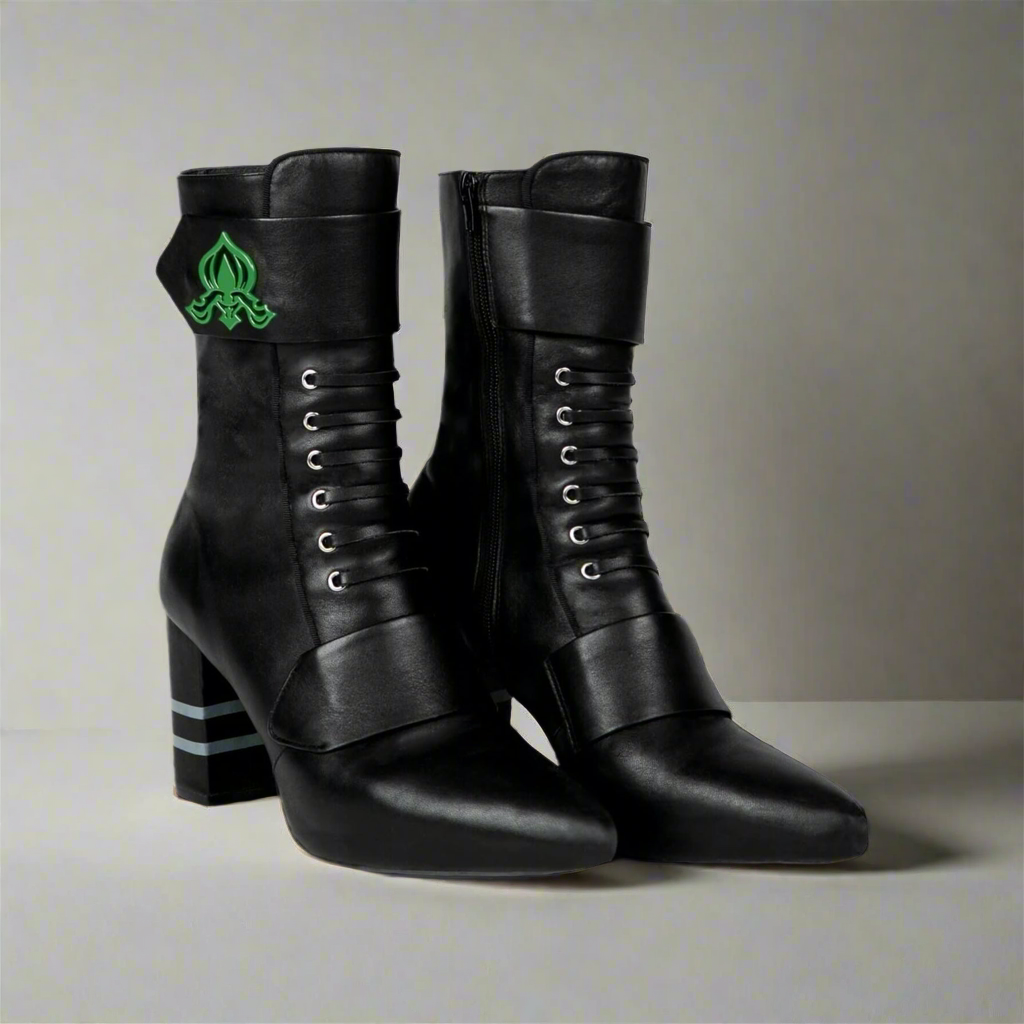 Black ankle boots front view with green fleur-de-lis emblem and lace-up eyelets