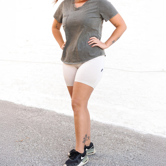 Clay light/cream biker shorts, fitted mid-thigh length with smooth waistband