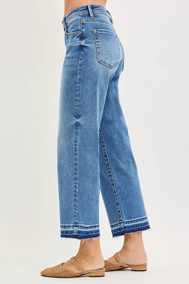 Medium wash boyfriend jeans, side view, relaxed fit with frayed cuffed hem