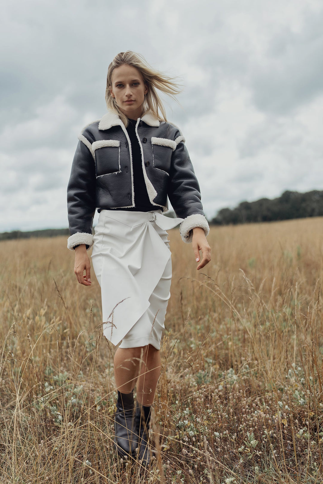 Black sherpa-lined leather jacket with cream trim at collar, cuffs, and hem