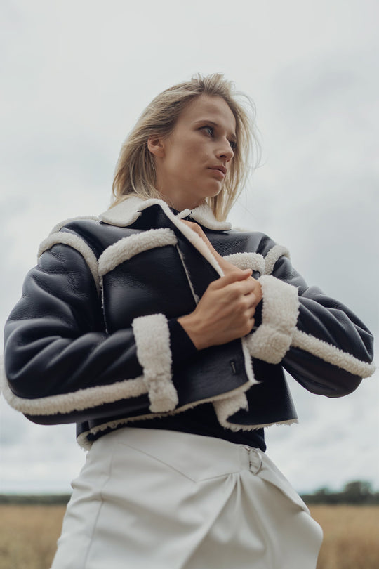 Black leather sherpa jacket with cream shearling collar and cuffs, button front