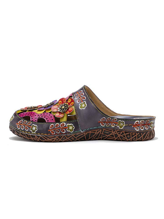 Floral slip-on sandal with dark upper, bright flower appliqués, and woven sole