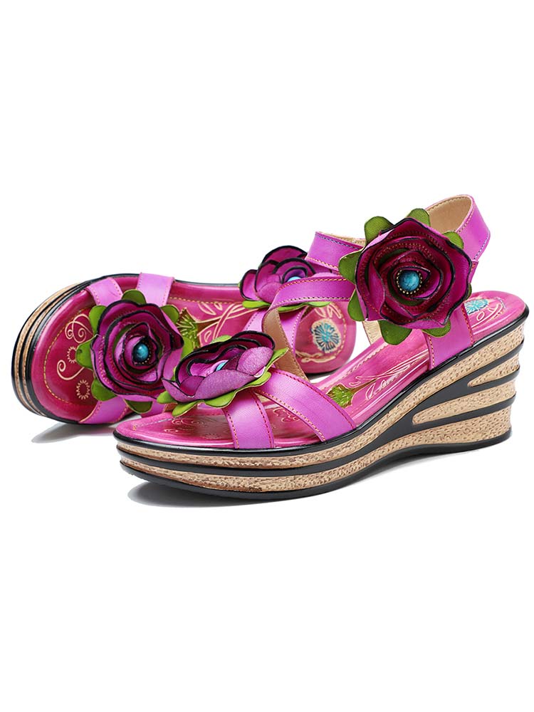 Pink wedge sandals with rose appliqués and patterned insole visible through straps