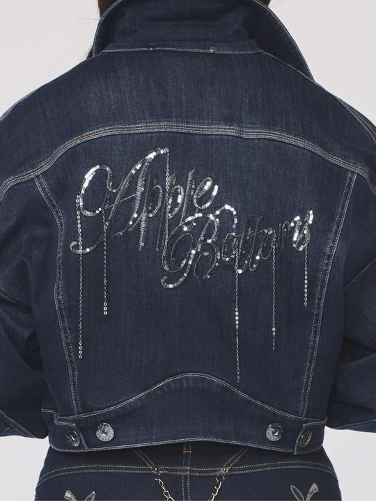 Denim jacket back panel with glittery chain-link script and curved top yoke seam