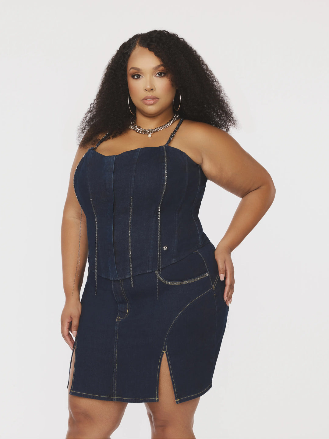 Bustier sin mangas de mezclilla azul con tirantes de cadena cruzados y costuras verticales.