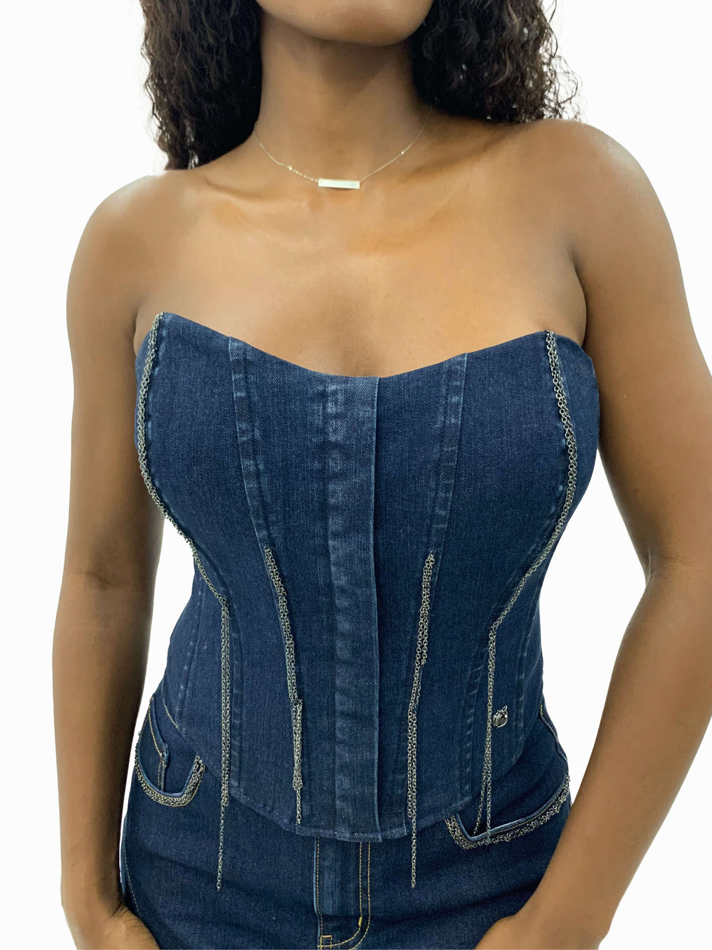 Bustier sin tirantes de mezclilla azul, paneles moldeados y correas de cadena laterales.