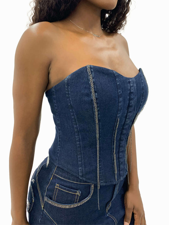 Bustier de mezclilla azul con escote corazón y cadenas decorativas colgantes.