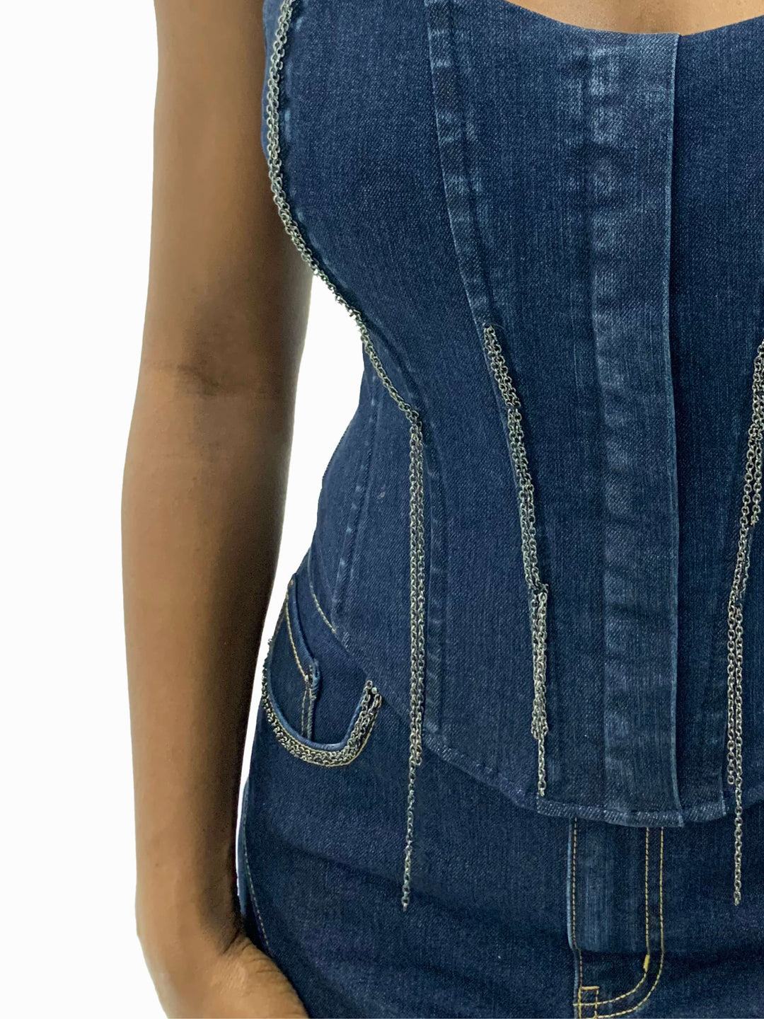 Bustier de mezclilla azul con bandas verticales y cadenas decorativas colgantes.