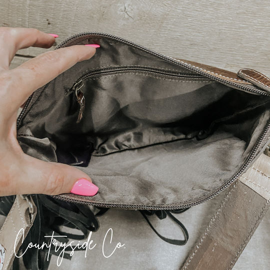 Cowhide purse interior with zippered opening and smooth gray lining