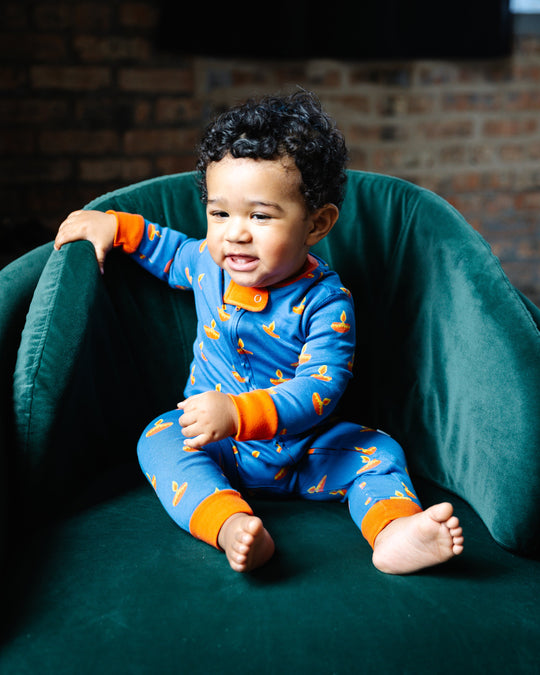 Blue baby sleeper with orange trim and yellow diya prints, zip-front footed design