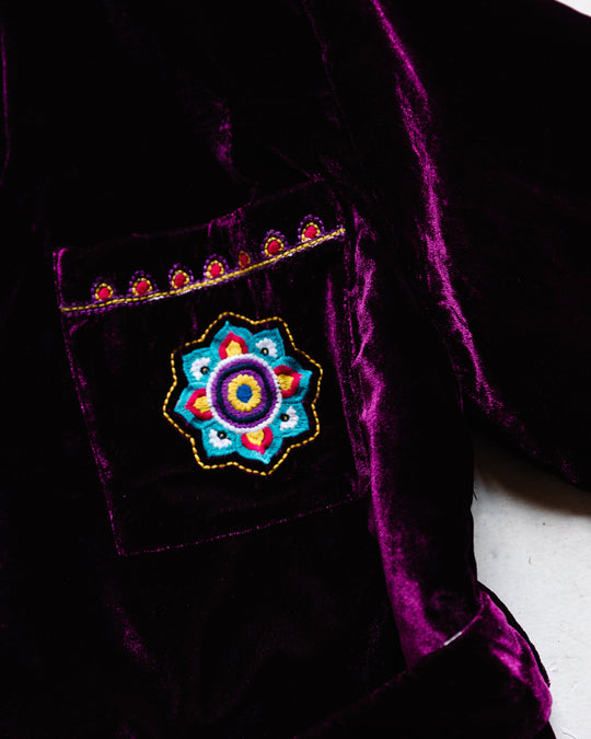 Purple velvet robe detail: embroidered floral medallion on chest pocket