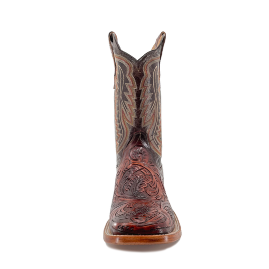 Cognac cowboy boot front view with carved toe, dark shaft panels and stacked sole