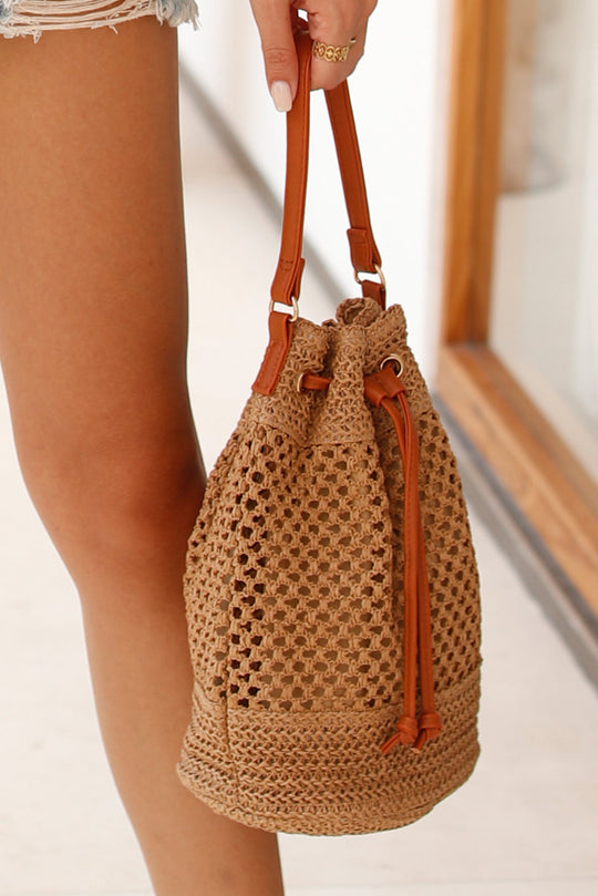 Khaki woven bucket bag with brown straps and drawstring cinch