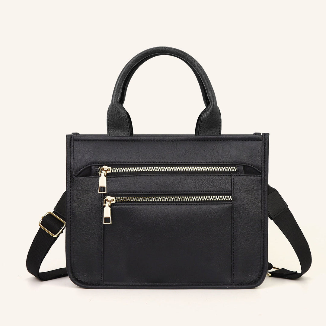 Black mixed-media tote with front dual zippers and two top carry handles