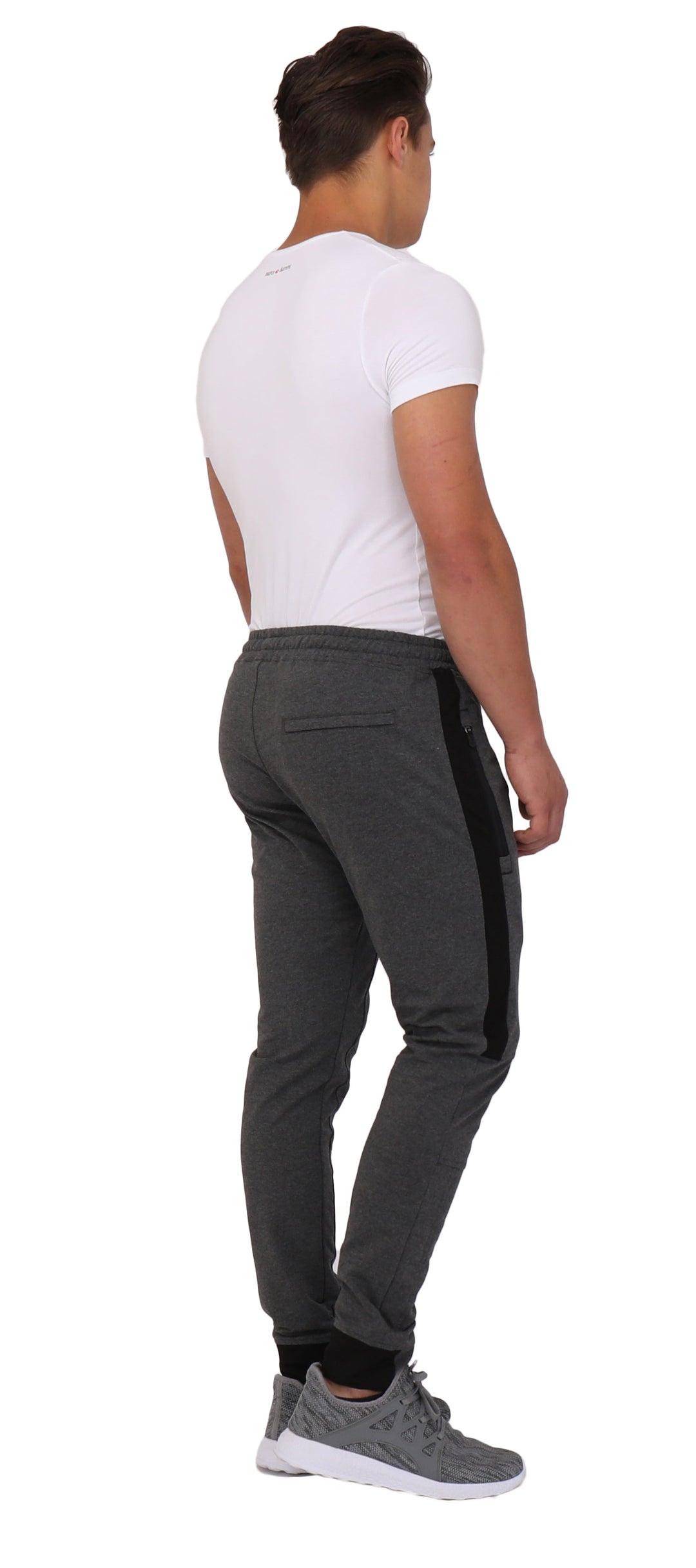 Dark grey/black joggers from the back with elastic waistband and side stripe