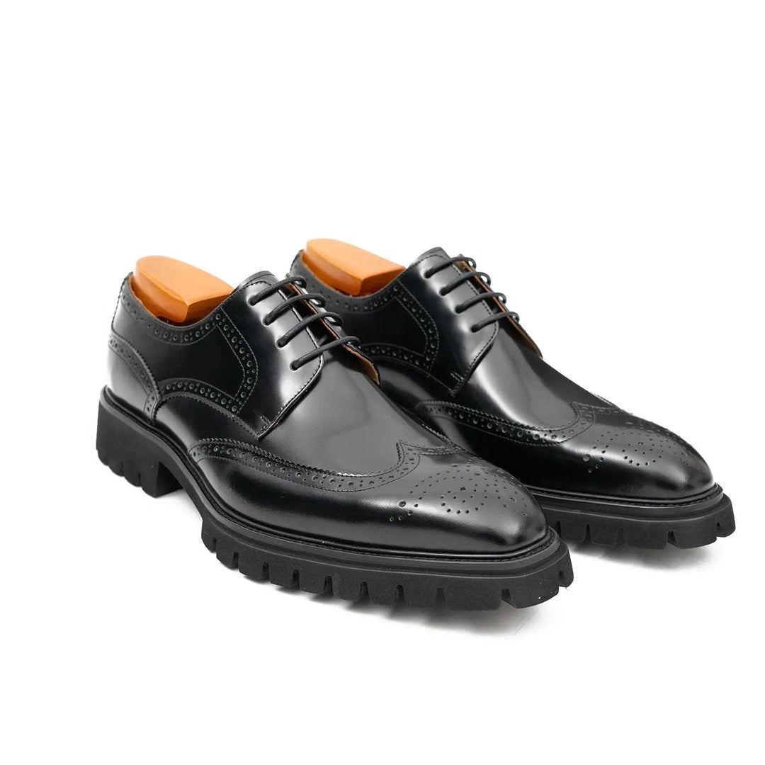 Black derby brogue shoes, side view with brogue panels, black laces, treaded sole