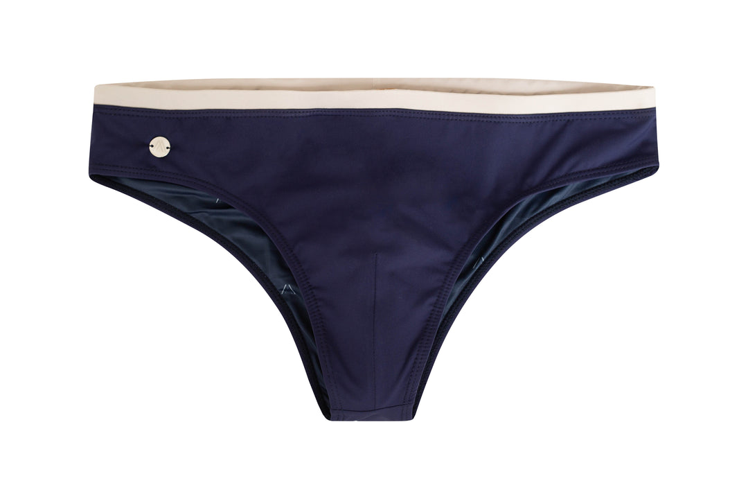 Midnight blue swim brief with beige inner waistband and round logo patch