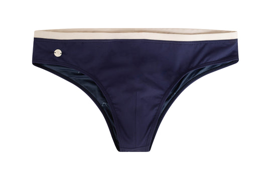 Midnight blue swim brief with beige inner waistband and round logo patch