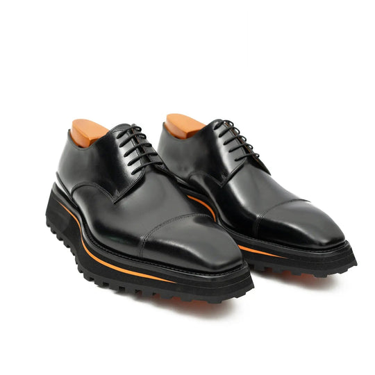 Black derby shoes side-by-side; lace-up vamp, orange stripe, thick outsole
