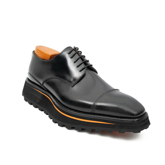 Black lace-up derby shoes with cap toe, orange welt stripe, rugged tread sole