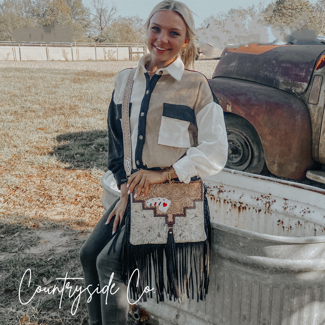 Cowhide fringe crossbody purse with black-and-white hair-on hide and black tassel fringe