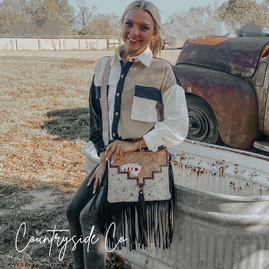 Cowhide fringe crossbody purse with black-and-white hair-on hide and black tassel fringe