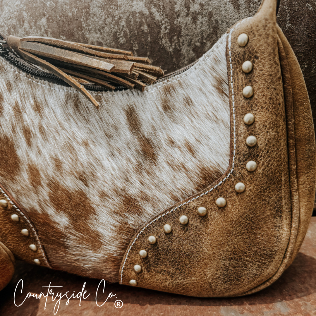Close-up of cowhide leather side panel with metal studs along the edge