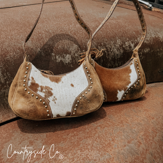 Rodeo Royalty cowhide handbag, brown-and-white hide with studded edge details