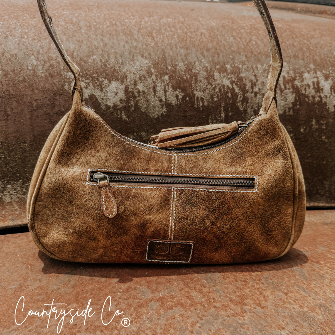 Cowhide leather hobo bag with top handles, zipper pocket, and small front logo patch