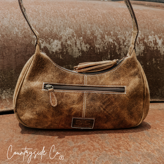 Cowhide leather hobo bag with top handles, zipper pocket, and small front logo patch