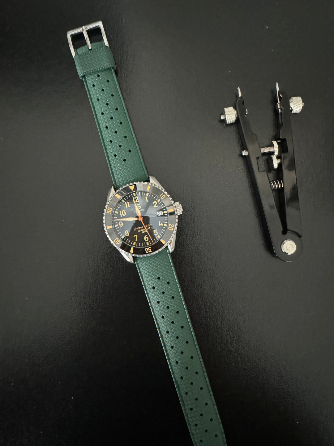 Tropic Bands watch with green perforated strap and silver buckle, dark dial