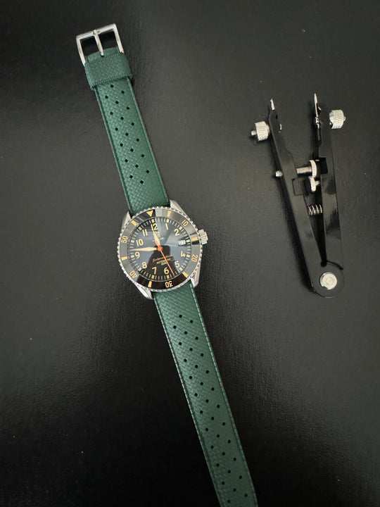 Tropic Bands watch with green perforated strap and silver buckle, dark dial