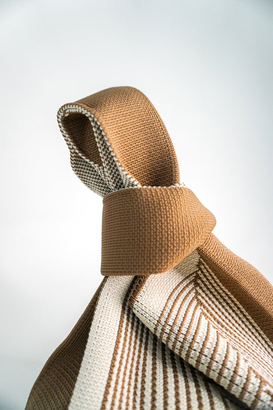 Beige twisted handle and woven labyrinth stripe pattern on bag body