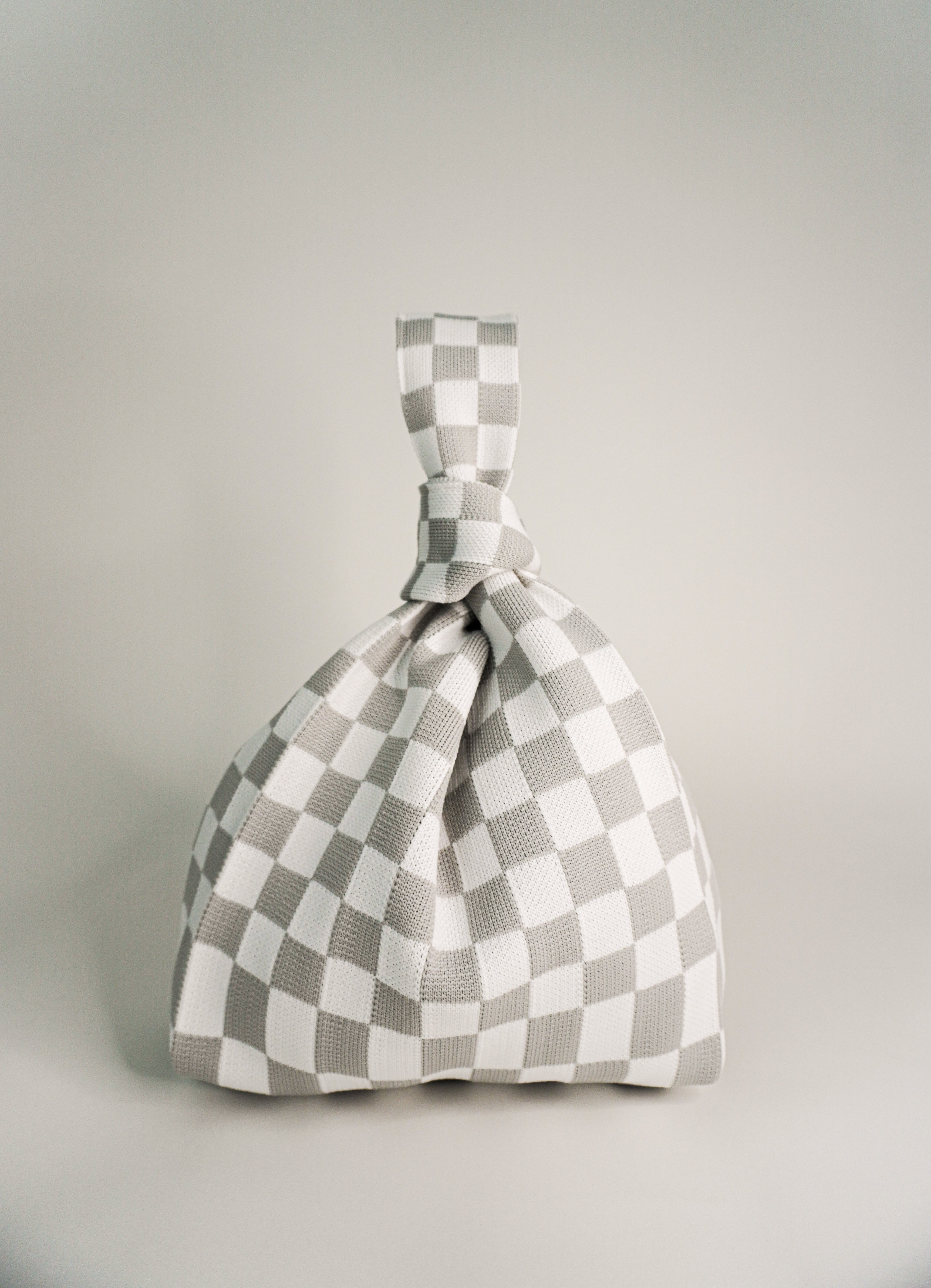 Classic checkered grey handbag with drawstring top and knot handle