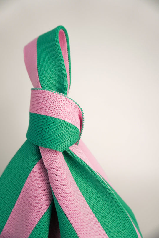 Close-up striped handbag bow strap in green and pink