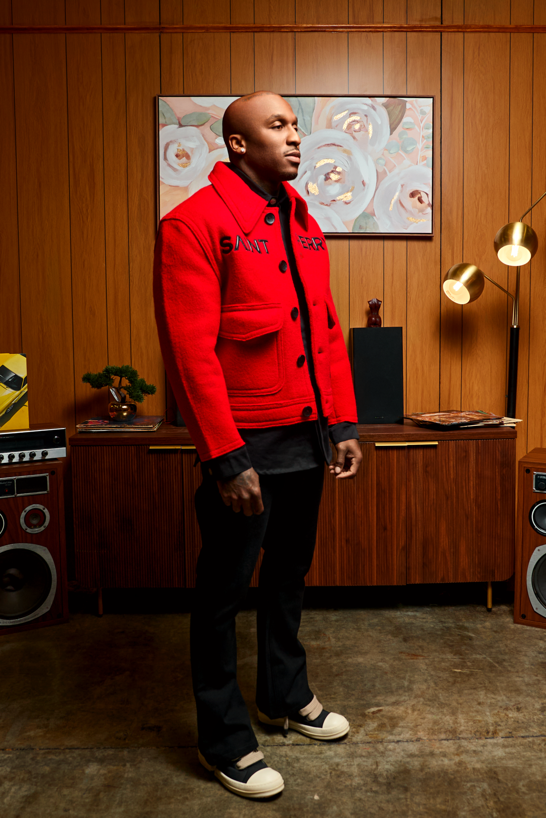 Red boxy jacket front three-quarter view with chest logo and black button placket