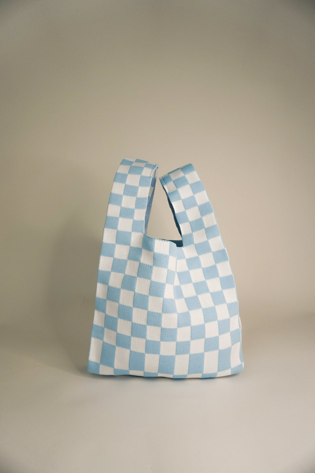 Classic checkered blue handbag with wide open handle and compact bucket shape