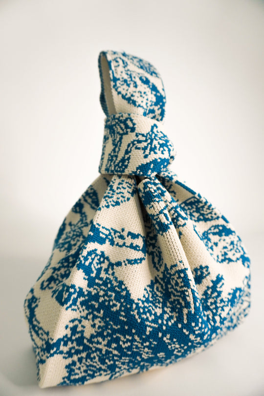 Blue and cream patterned drawstring handbag with gathered top and hanging cord.